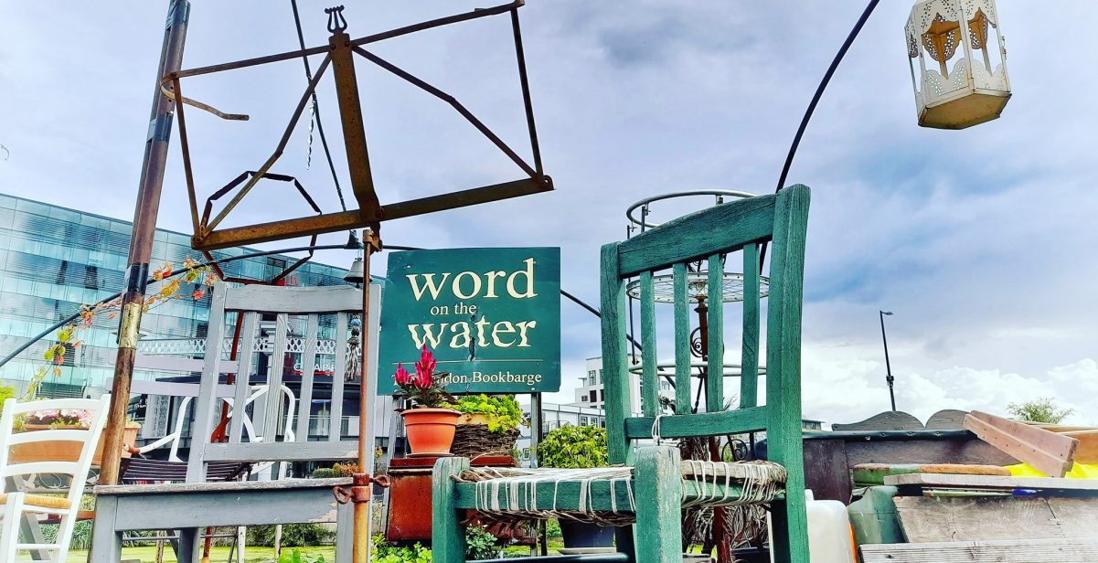 Blue chair, clear sky, sign saying Word on the water