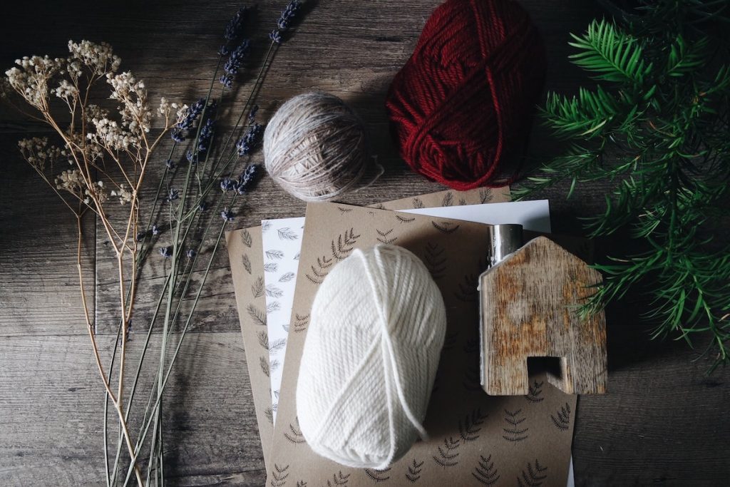 Materials to make Christmas table decorations: wool, card, and dried flowers