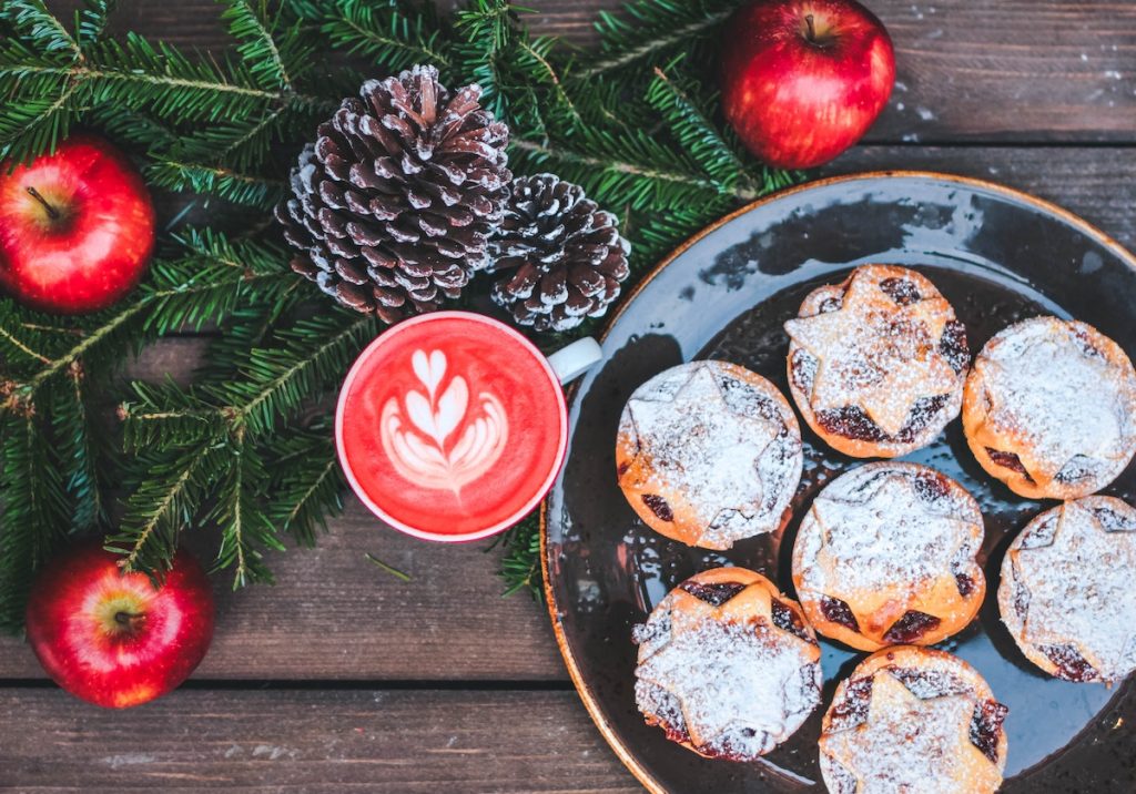 Mince pies on a plate, pinecones and apples