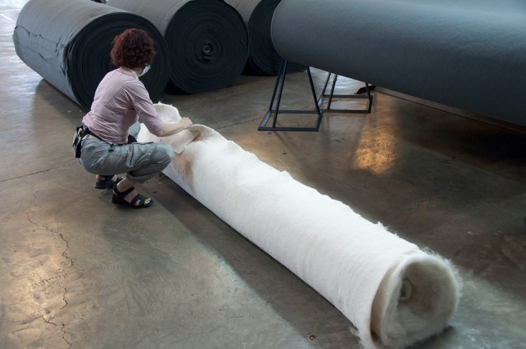 Hijosa kneels over rolled material