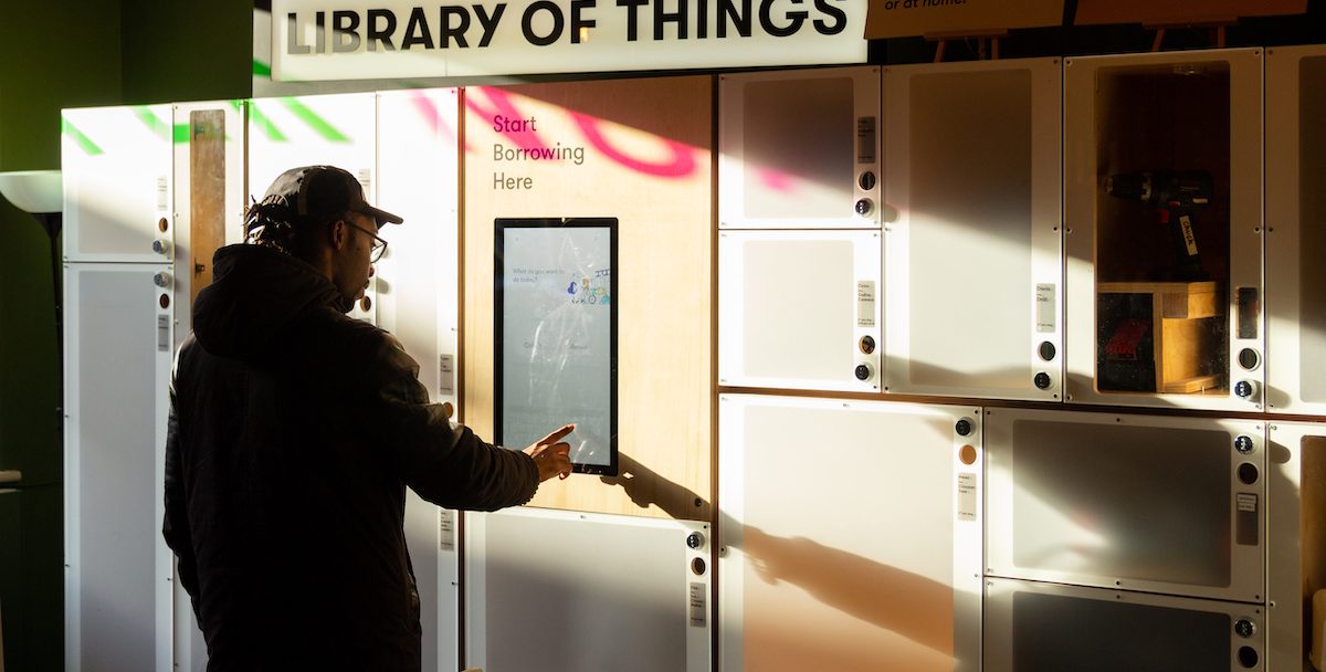 Man under sign that says 'library of things'