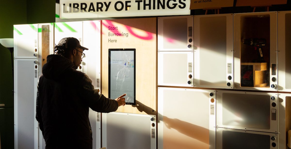Man under sign that says 'library of things'
