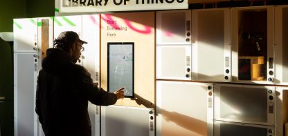 Man under sign that says 'library of things'