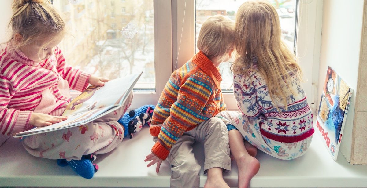 Three children looking out of window