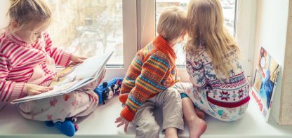 Three children looking out of window